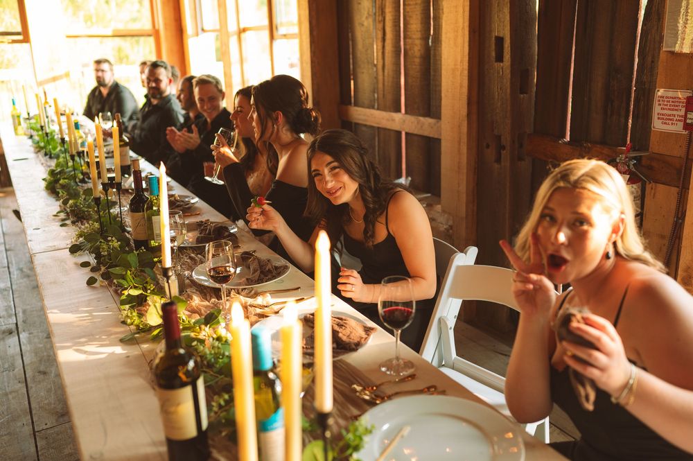 A group of people enjoying drinks at a rustic wooden bar with natural lighting streaming through windows.