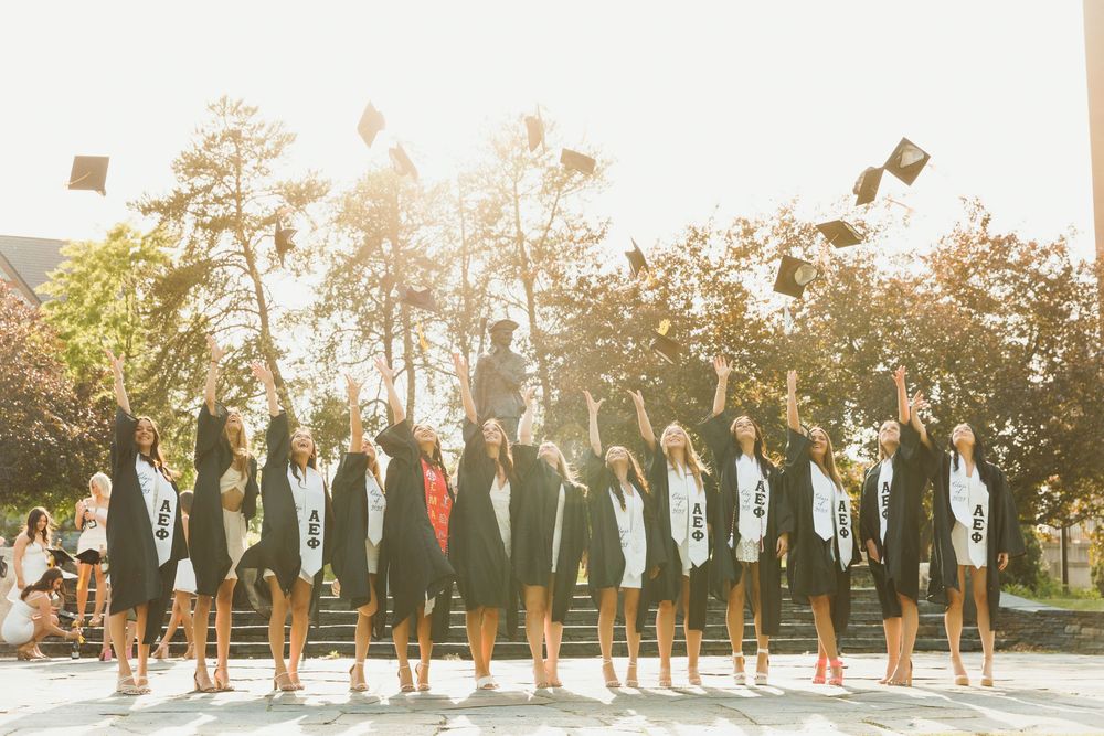 Graduates toss their caps in celebration during sunset ceremony.