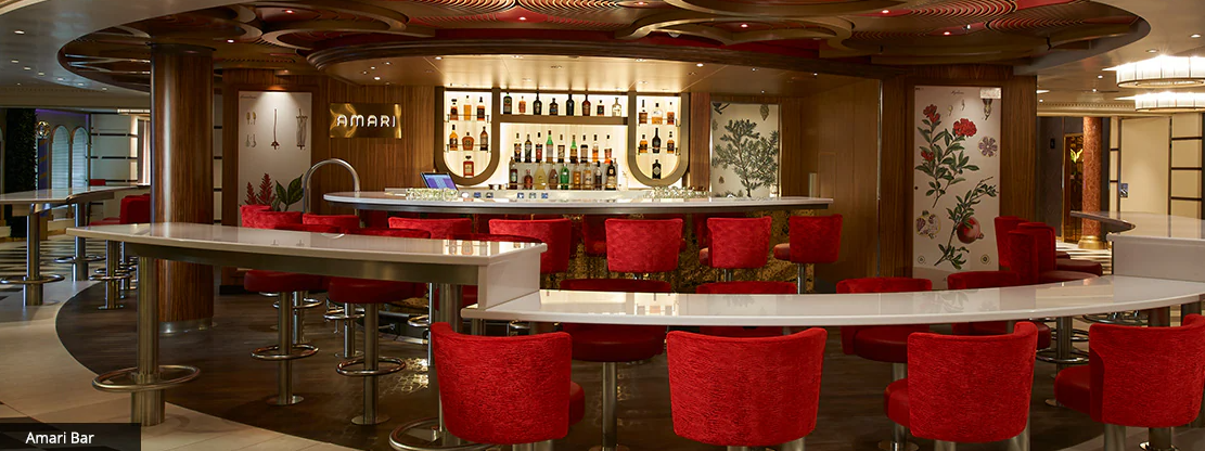 Modern hotel bar interior with red bar stools and warm lighting creates an inviting atmosphere for guests.