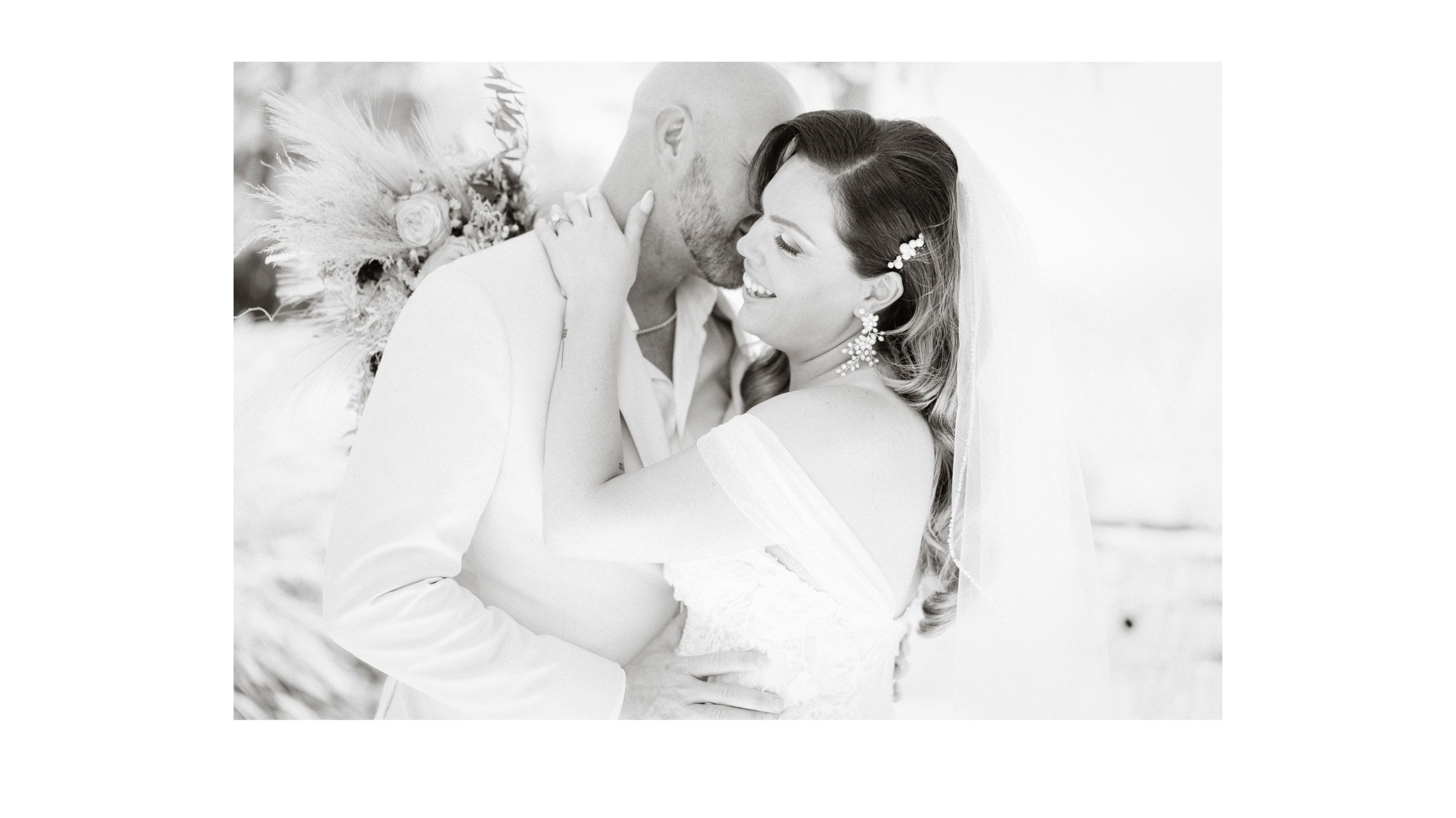 Black and white candid wedding photo capturing joyful laughter.