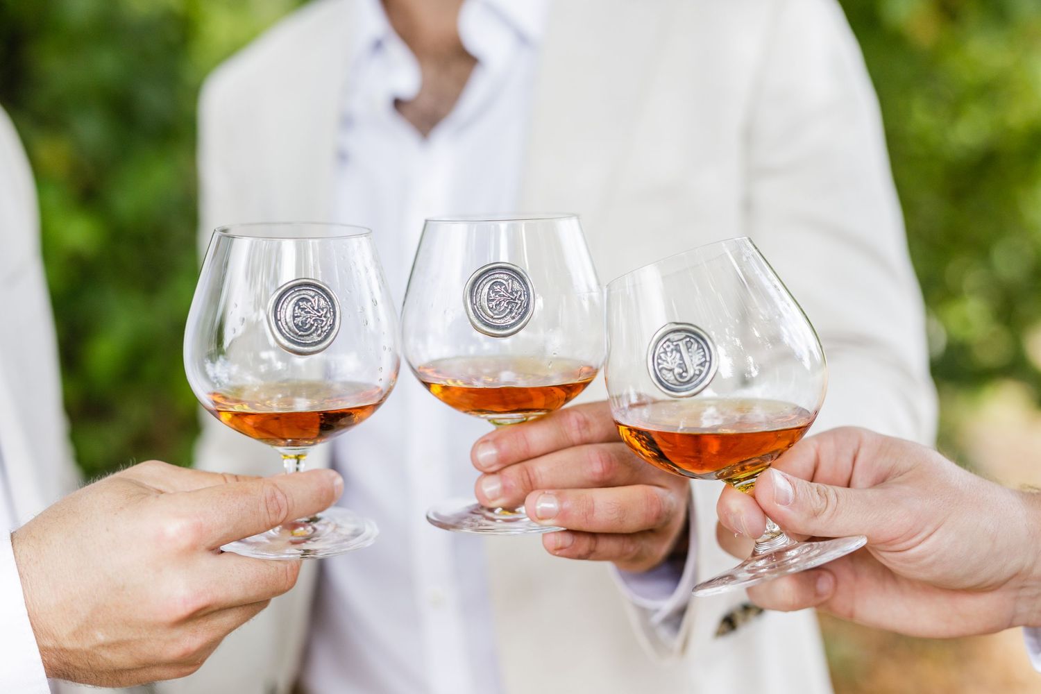 People toasting with glasses of rose wine during an outdoor celebration or gathering.