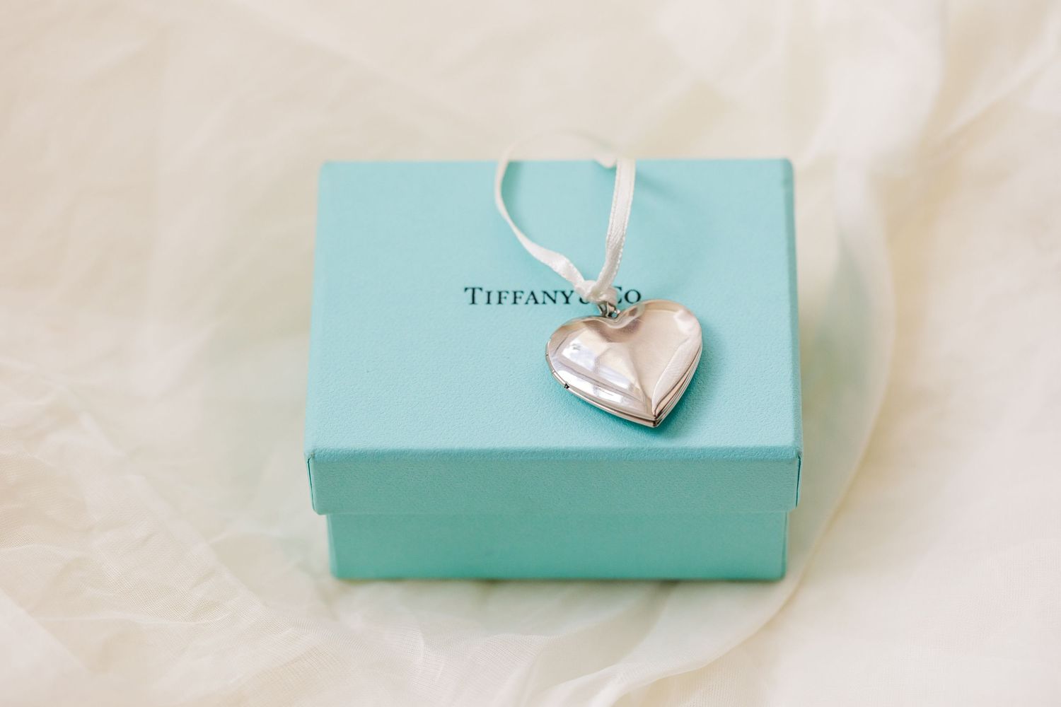 A collection of iconic Tiffany & Co. blue boxes and shopping bags arranged on a light colored surface.