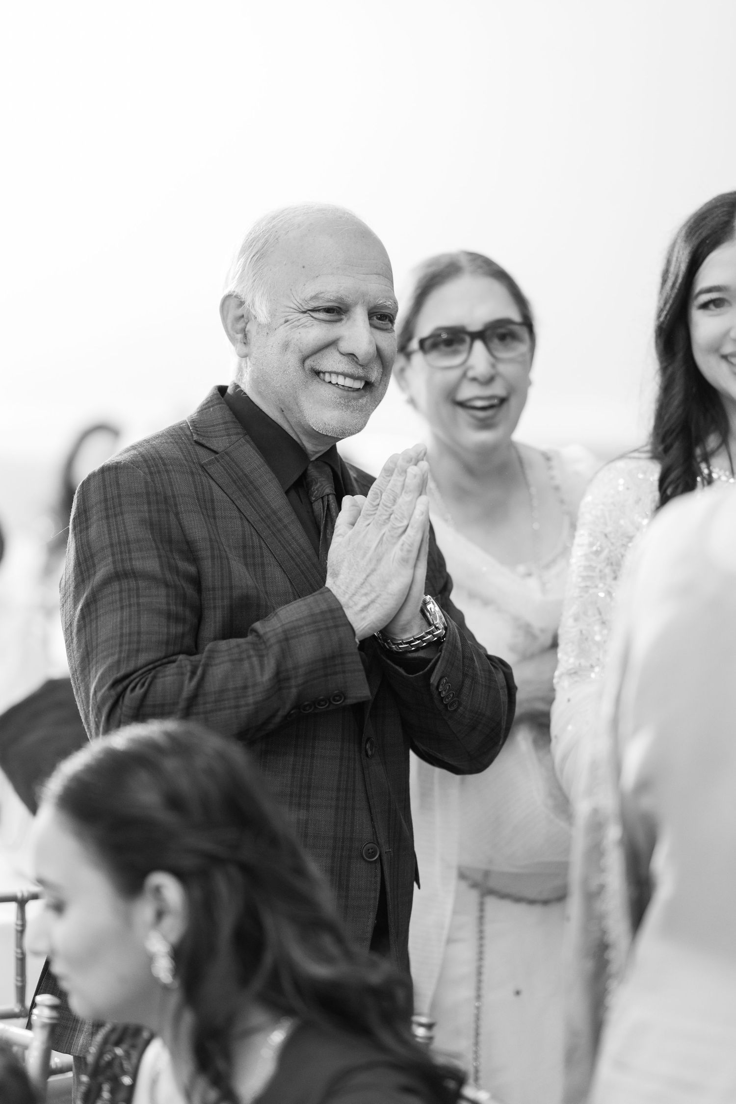 Three candid black and white photos show joyful reactions and laughter during a social gathering.