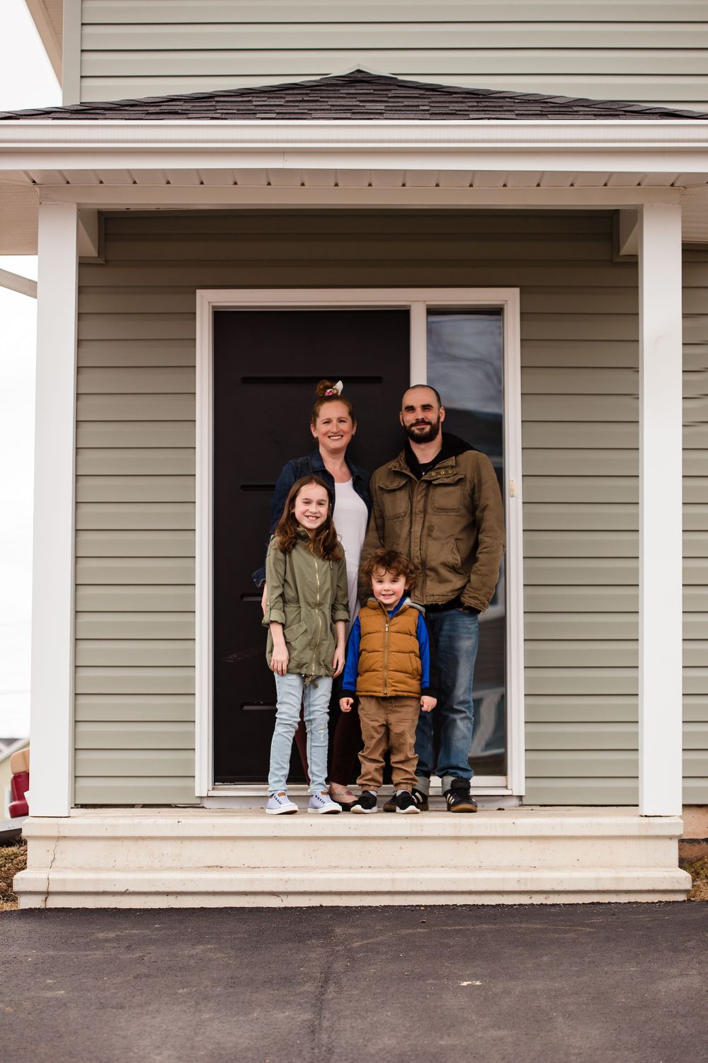 Family poses together in different window frames of their house.