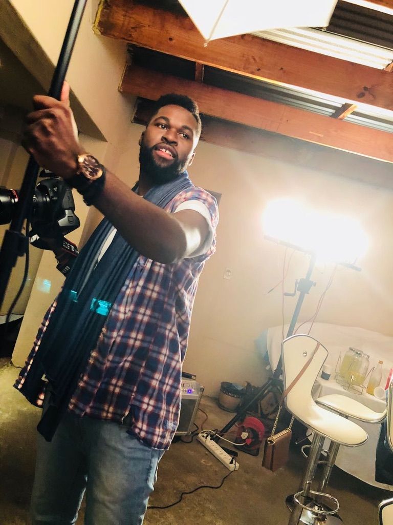 Behind-the-scenes shot of videographer working with professional camera equipment.