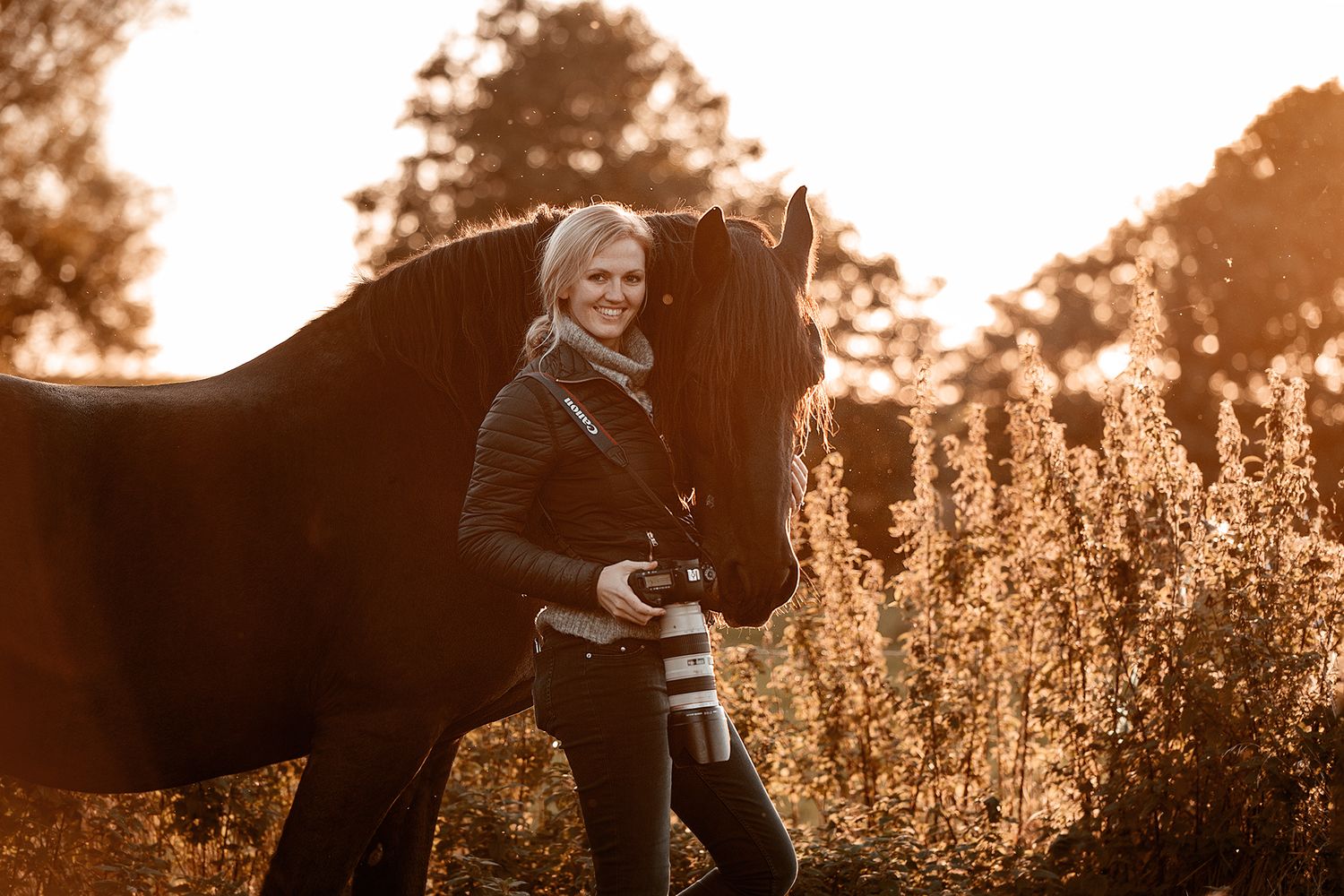Warm sunset photo of a horse and photographer in a field of tall wildflowers.