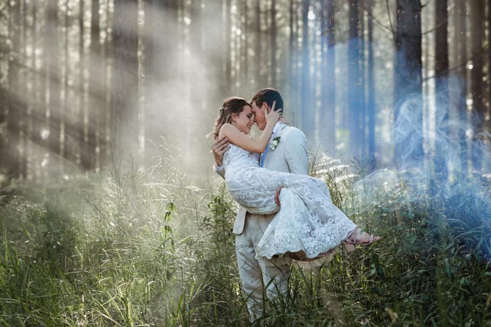 Romantic couple embrace in misty forest with ethereal lighting effects.