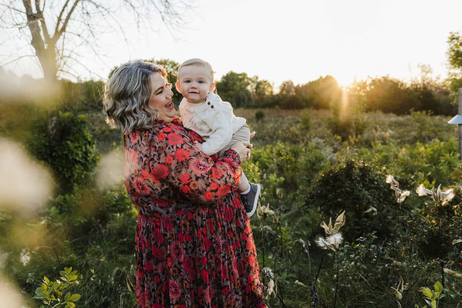 Mom in long flowly dress takes photos with one year old son with sussex wisconsin photographer.