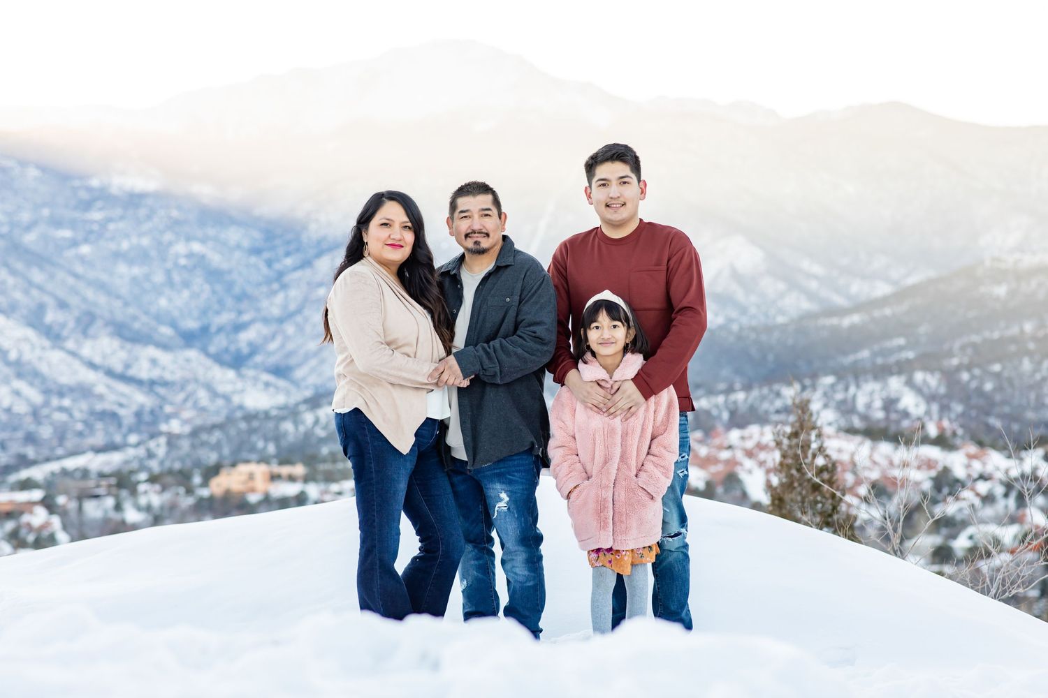 Parents with their son and daughter pose together in the snow at Garden of the Gods in Colorado Springs.