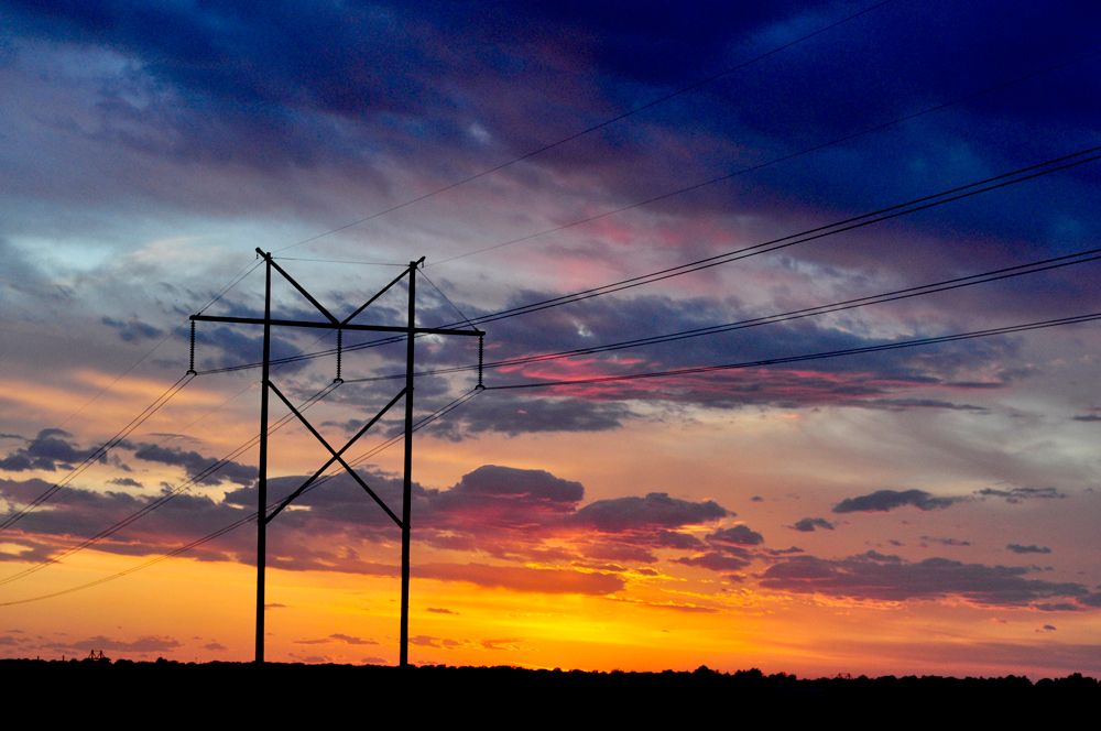 Powerlines at sunset showing orange, pink, and blues