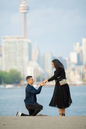 Romantic proposal scene with Toronto cityscape and CN Tower as backdrop.
