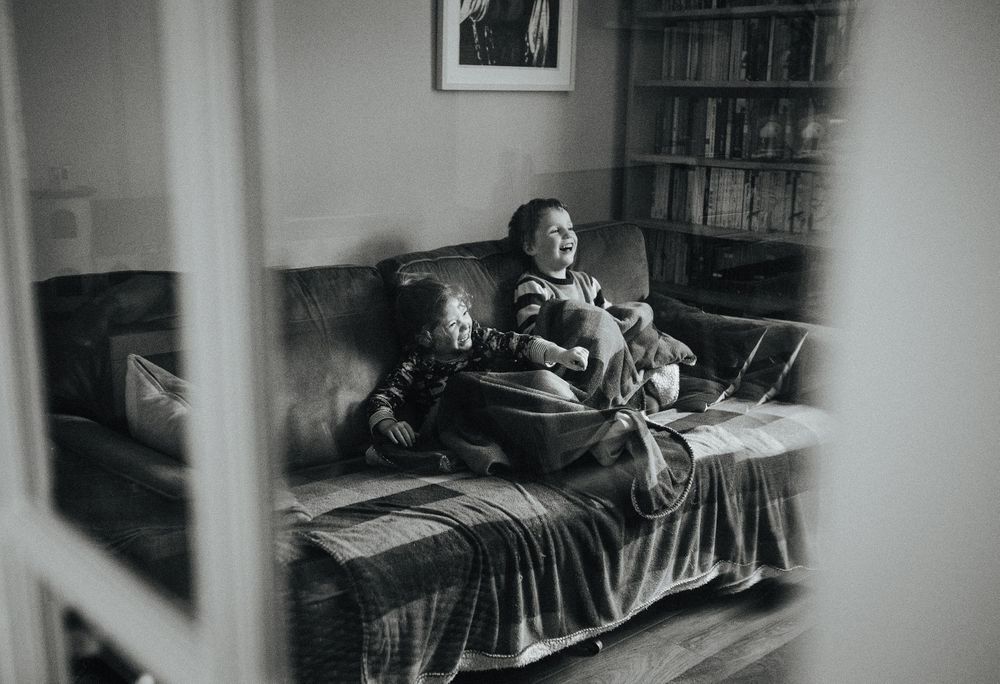 A joyful moment captured in black and white of someone relaxing on a couch.