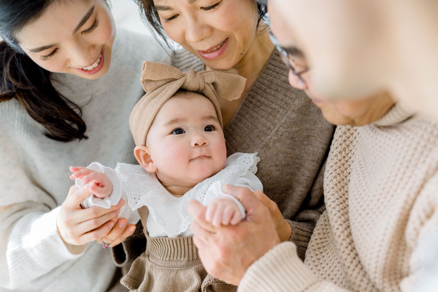 A heartwarming family moment with a baby being cradled in cozy knit sweaters.