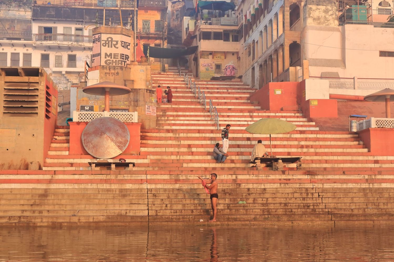 Morning light illuminates the ancient stone steps of Varanasi's ghats along the Ganges River.