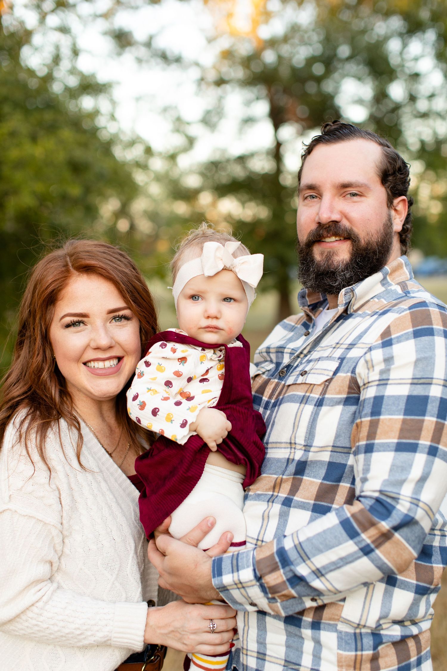 Outdoor portrait of family in coordinated casual wear during golden hour.