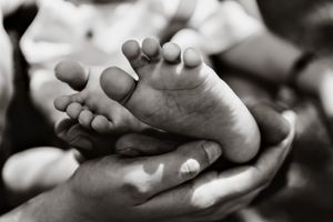 Black and white artistic photo of tiny baby feet.