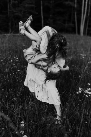 A joyful black and white photo of playtime in a summer meadow.