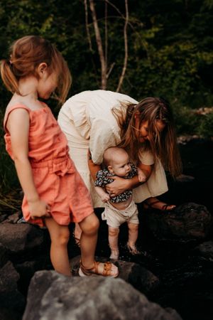 People exploring rocky terrain together on a sunny afternoon while wearing summer attire.