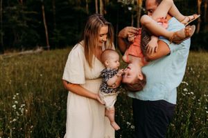 Family sharing joyful moments together in a wildflower meadow at sunset.