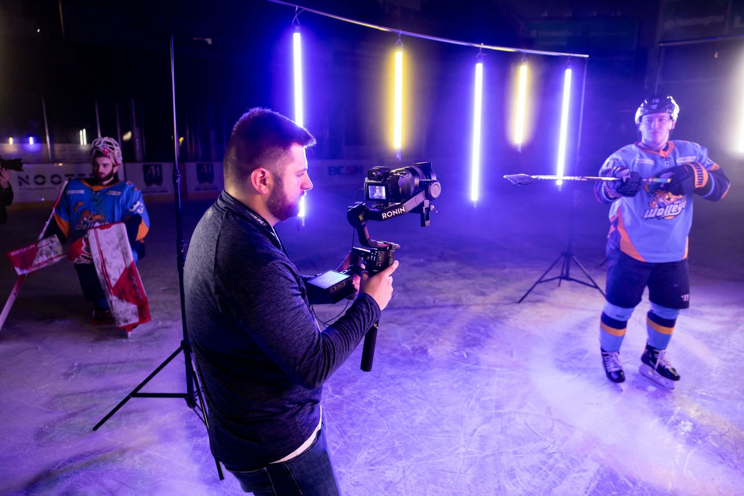 Behind the scenes filming of a hockey player against colorful LED lights.
