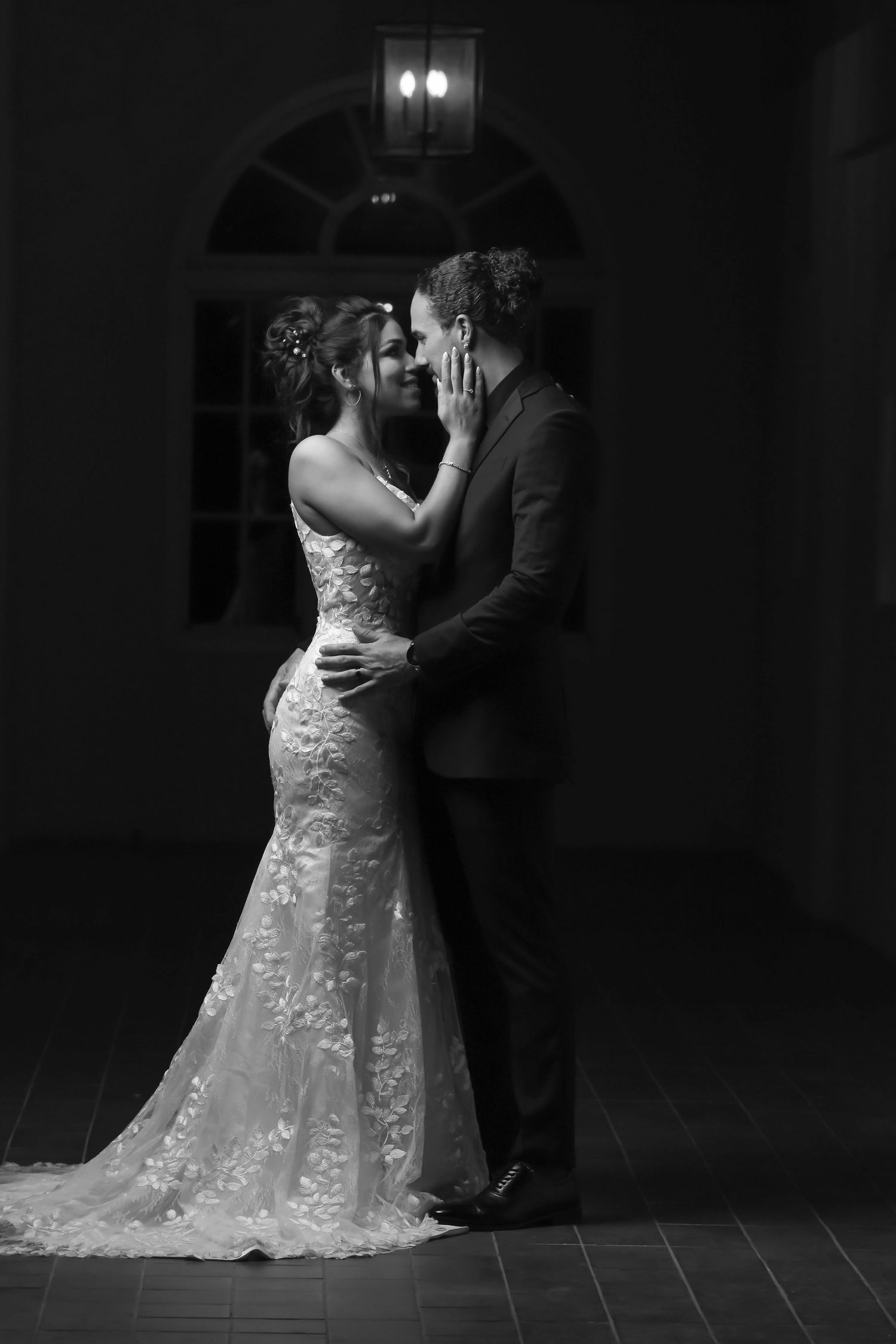 A romantic black and white photo series of a couple in wedding attire dancing together in a dimly lit room.