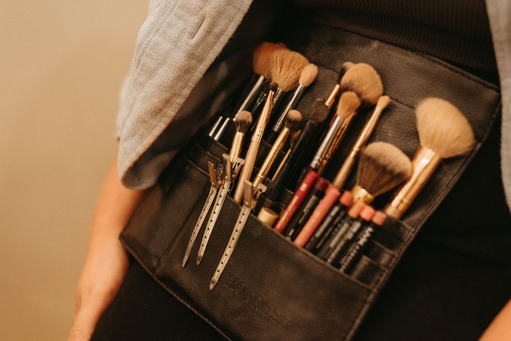 Collection of professional makeup and beauty tools arranged in black storage case.