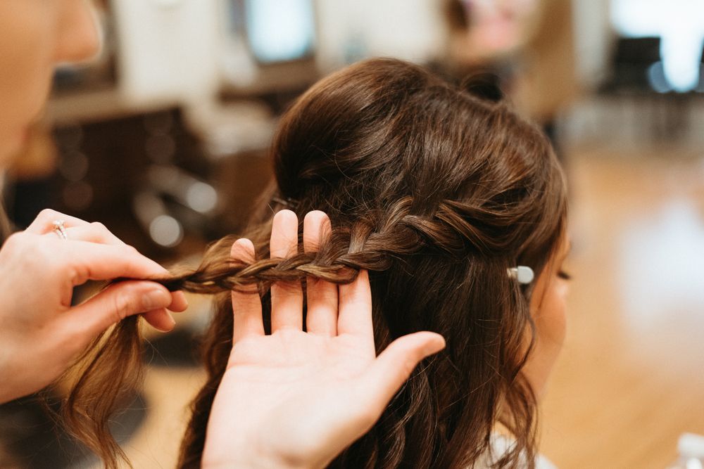 Close-up of hair being braided with detailed technique shown.
