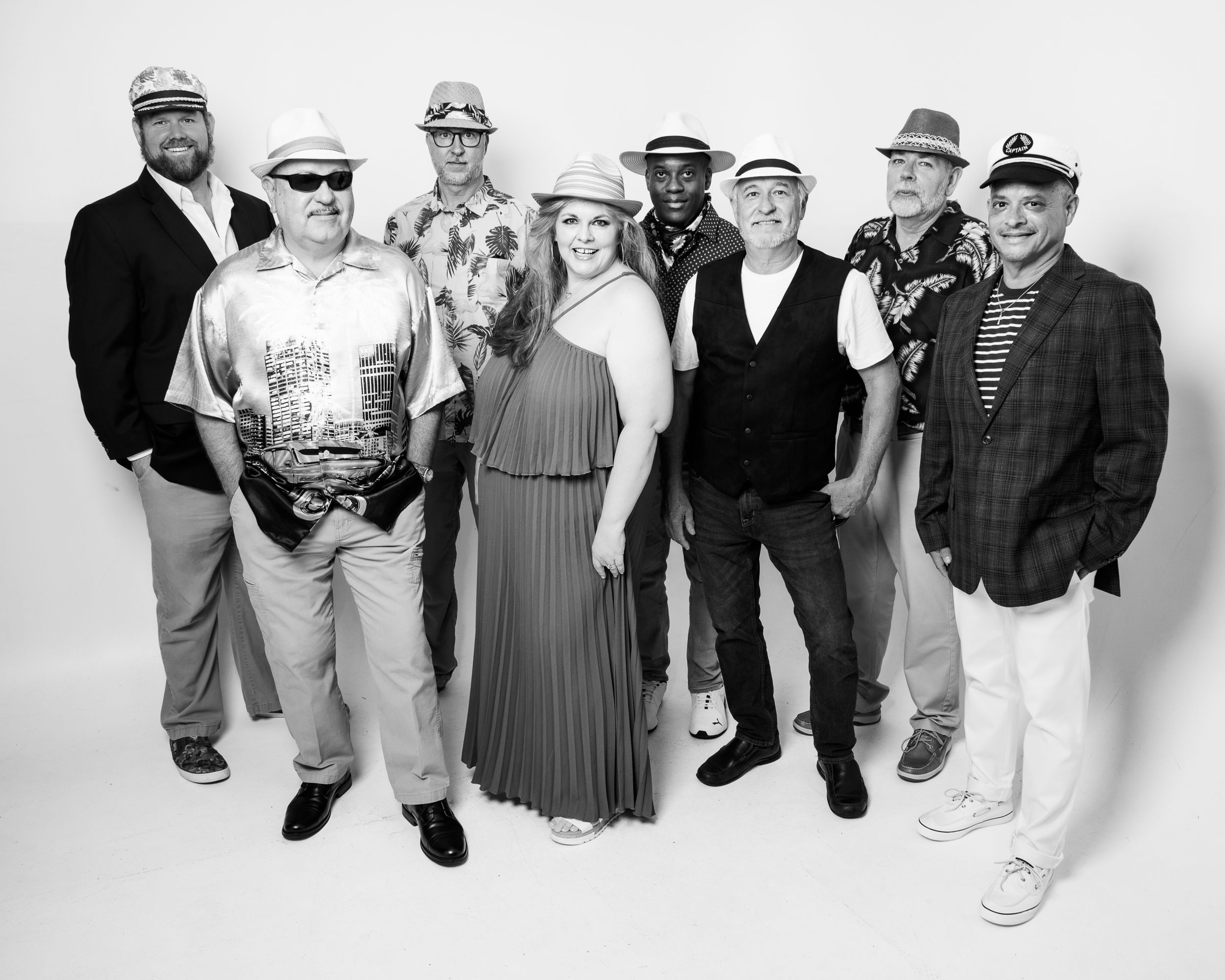 Black and white group photo showing people lined up in casual attire against a white backdrop.