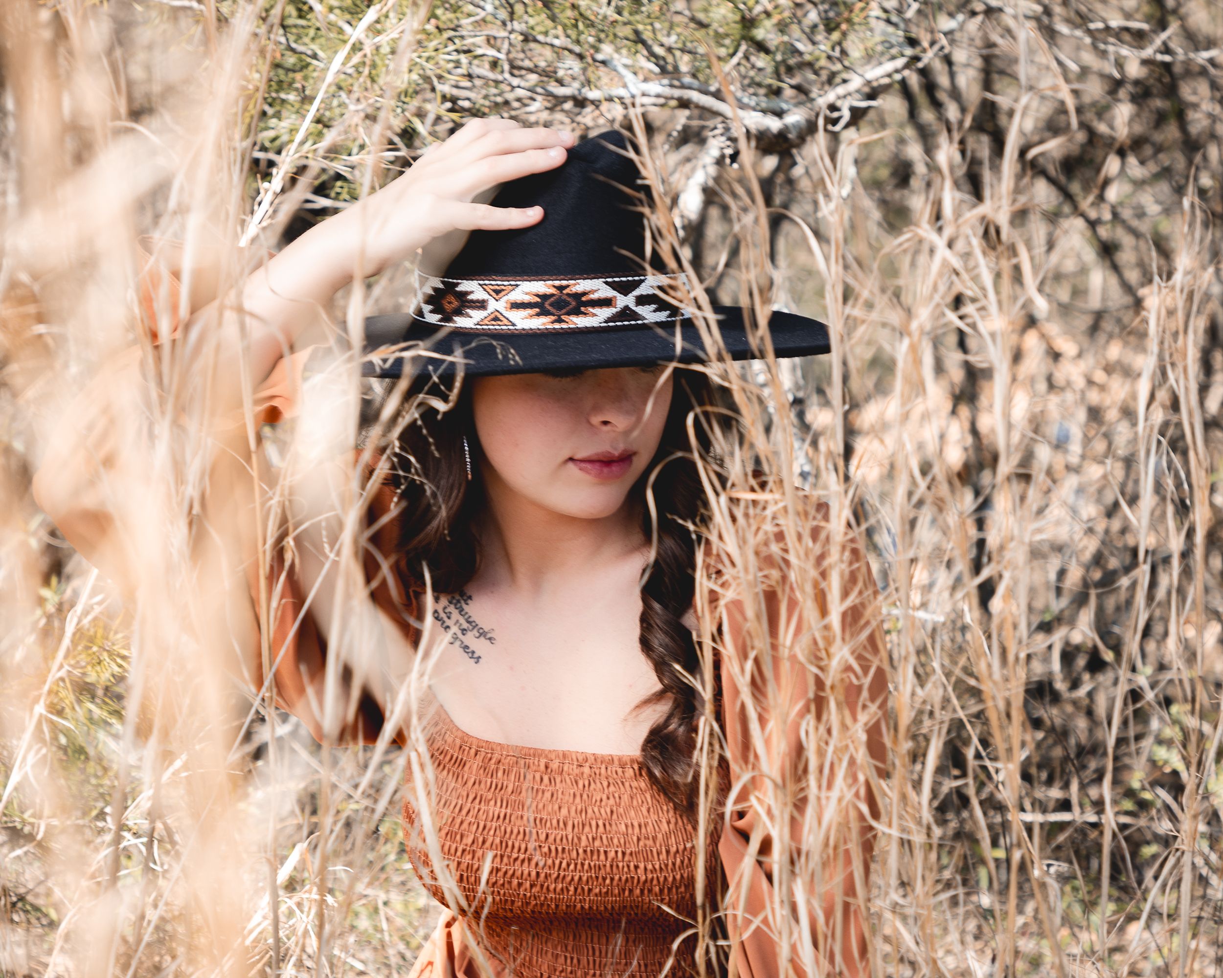 Artistic outdoor portrait series in a field of tall dried grass and natural lighting.