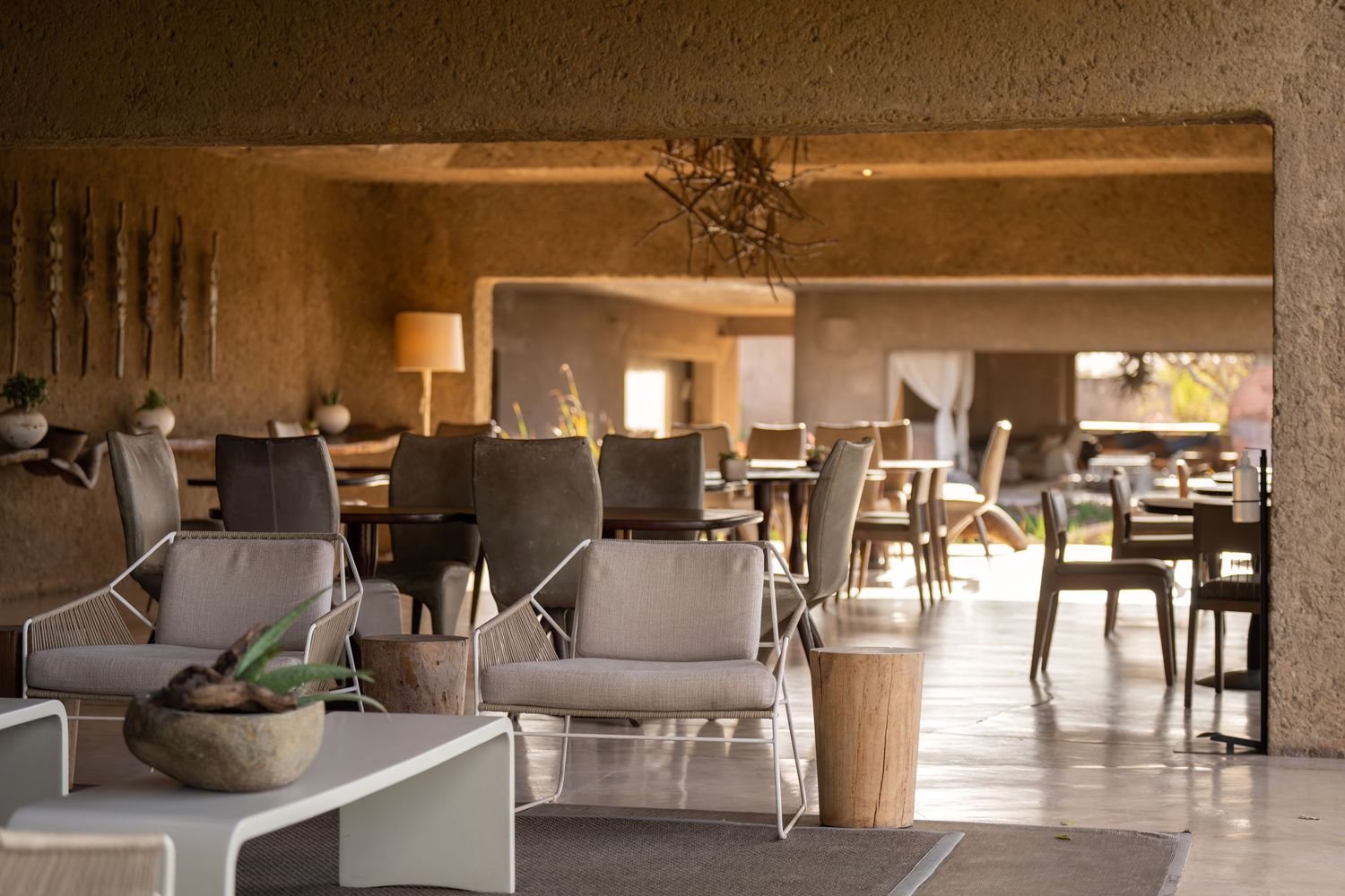Elegant safari lodge interior with comfortable gray seating and natural lighting.