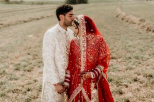 Intimate wedding portrait showing couple in ornate traditional South Asian ceremonial attire.