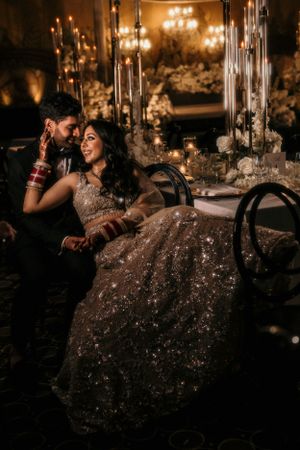 Romantic candlelit wedding photo showing a couple sharing an intimate moment among elegant decorations.