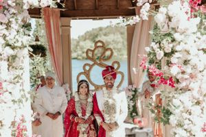 Decorated wedding mandap with floral arrangements and gold accents during ceremony.