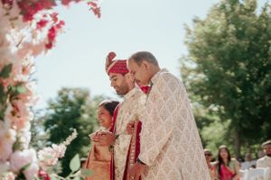 Outdoor wedding ceremony with traditional cultural attire and floral decorations.