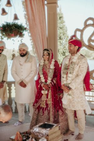 Traditional Indian wedding ceremony taking place in an outdoor pavilion with elegant decor.