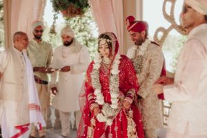 Traditional ceremony with participants gathered under decorated outdoor pavilion.