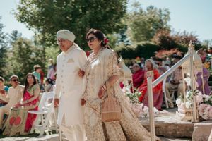 Traditional wedding ceremony outdoors with attendees in formal cultural attire and floral decorations.