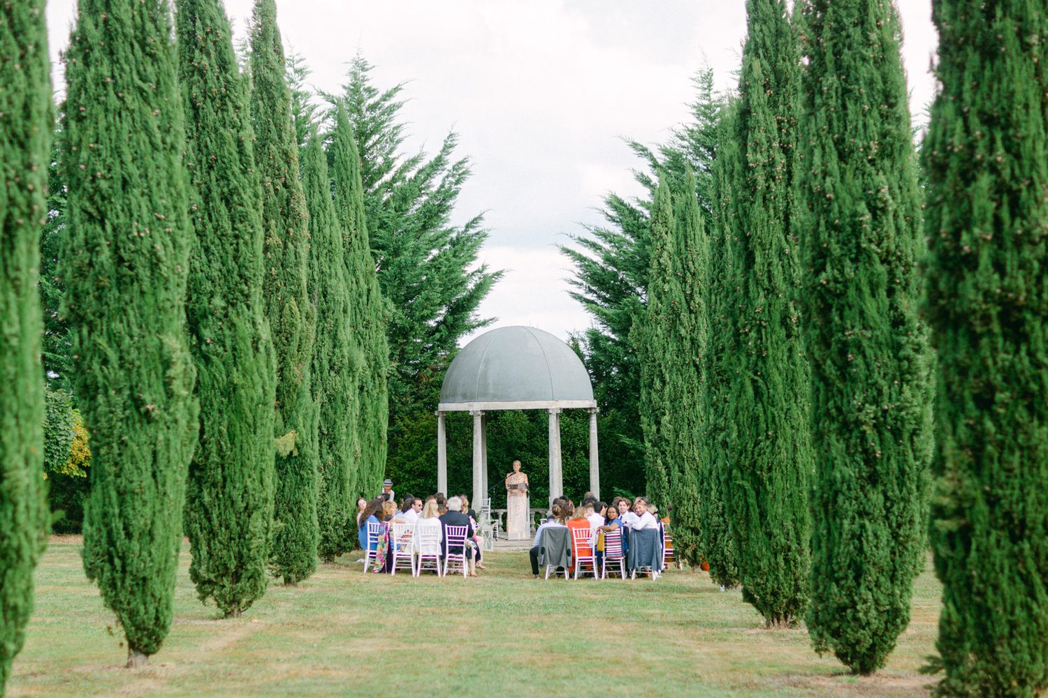 Installation de cérémonie de mariage avec un gazebo blanc encadré par de grands cyprès au chateau de la Durantie