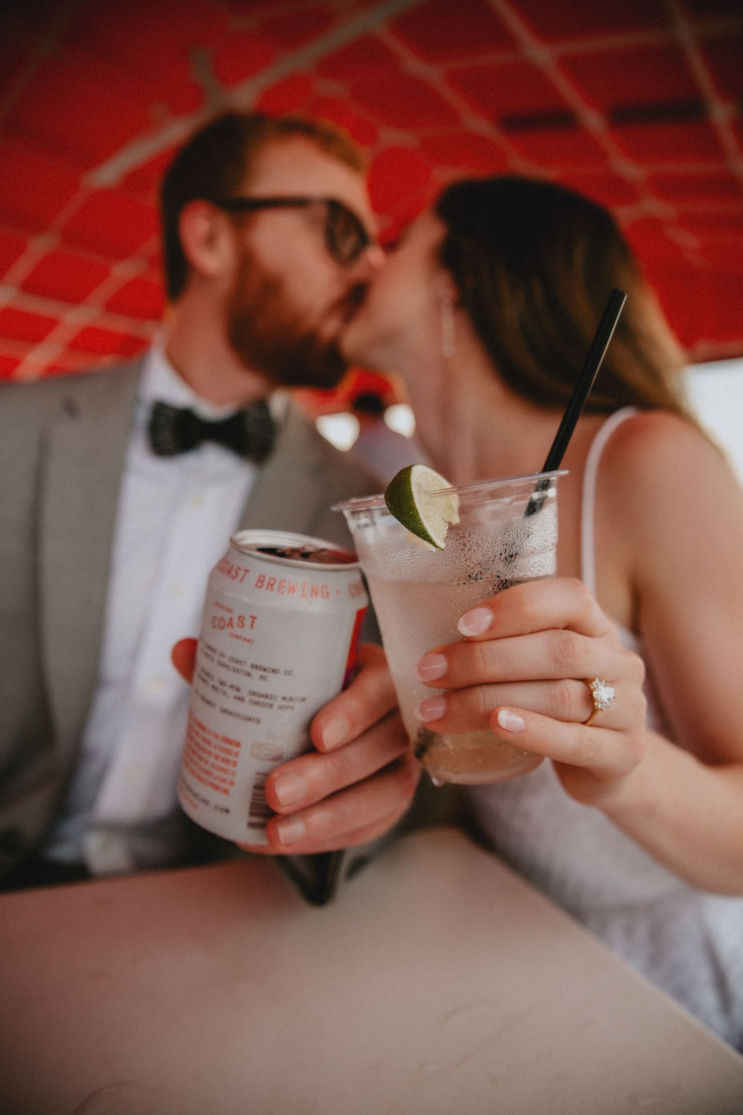 A couple holding their drinks out in front of them