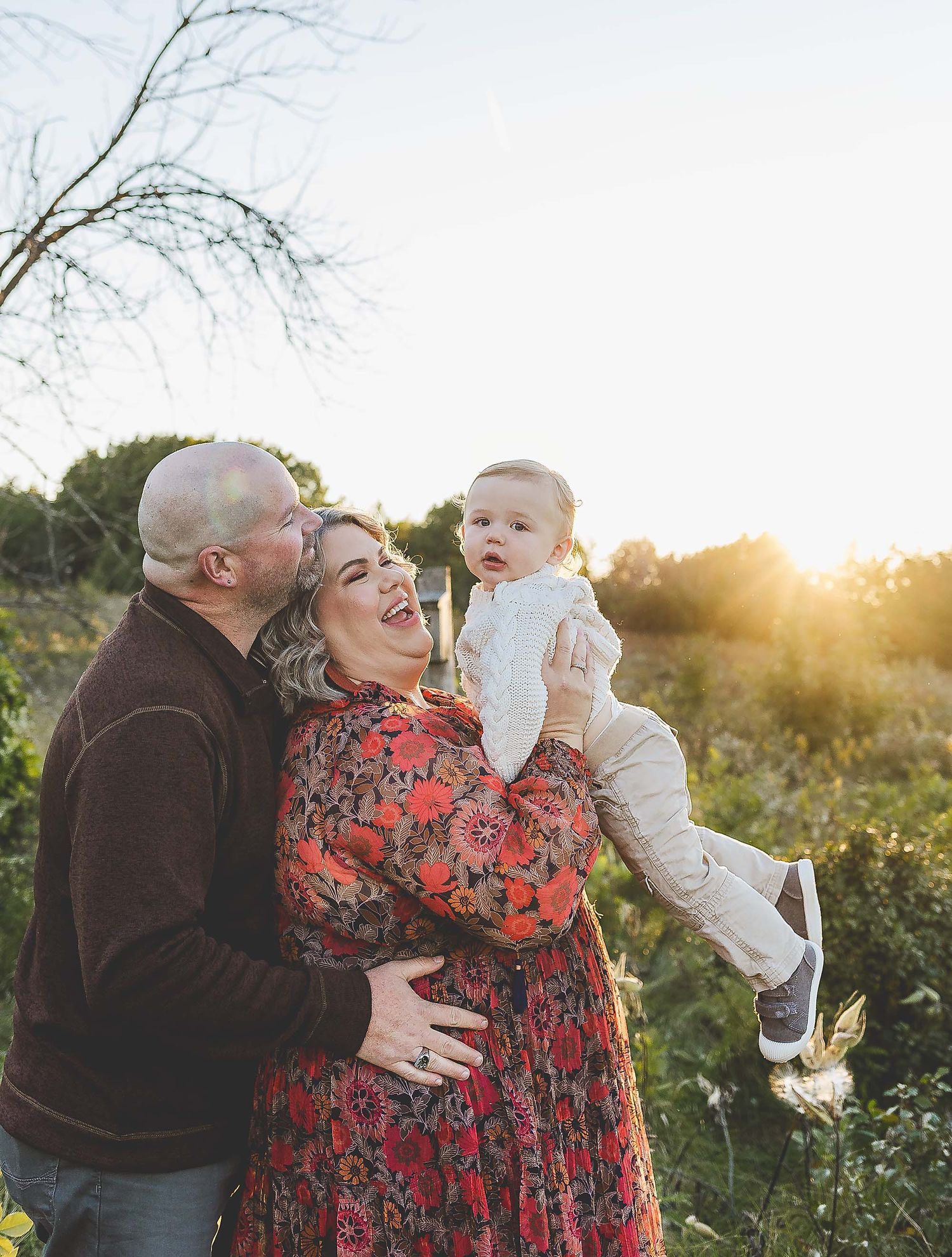 Mom and dad throwing little boy up in the air to take family photos with Oconomowoc photographer.
