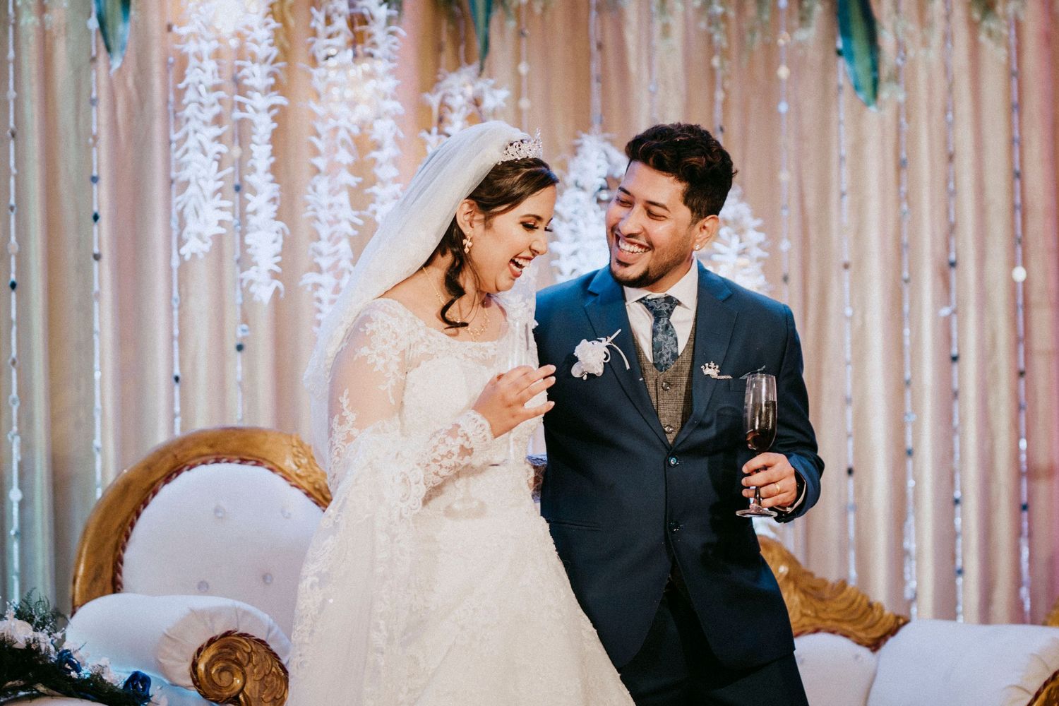 Bride and groom share candid reactions during their wedding celebration.
