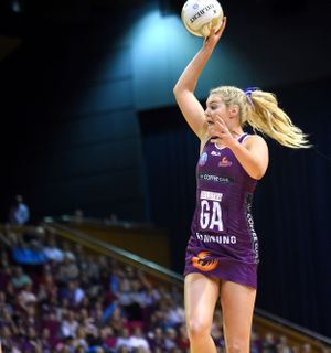 Netballer jumps with ball in hand