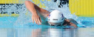 Swimmer splashing while taking a stroke