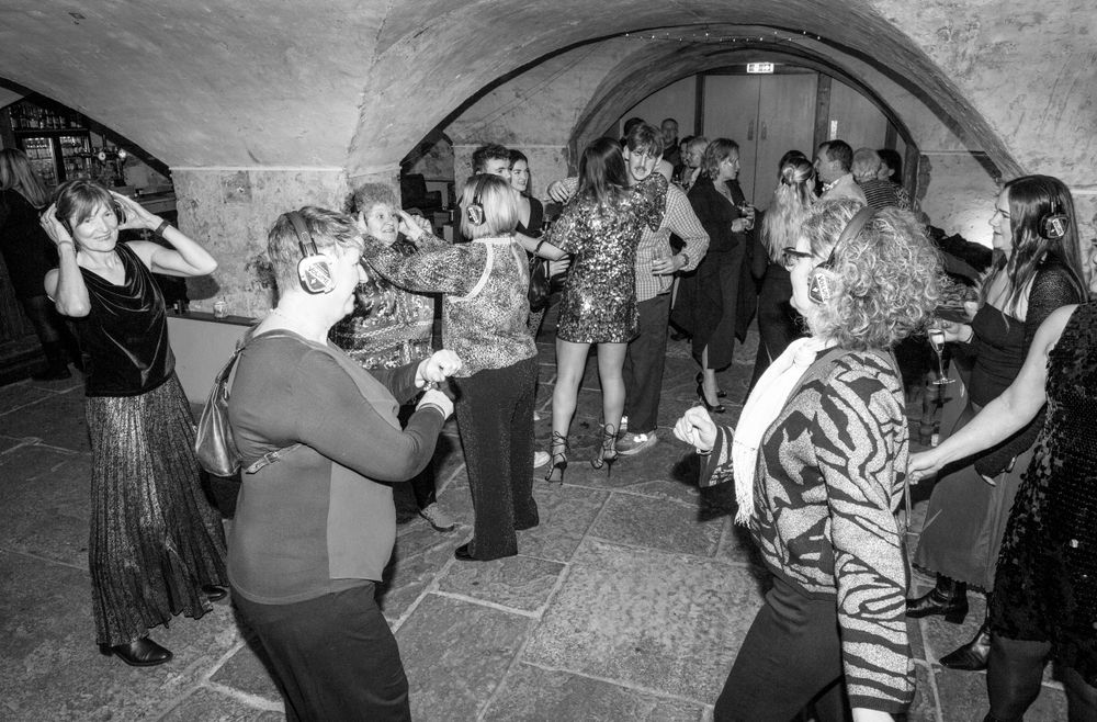Silent disco. Party guests dancing. Black and white shot.