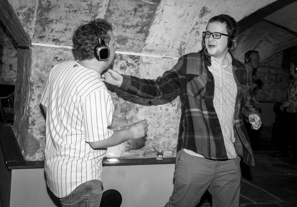Silent disco. Party guests dancing. Black and white shot.