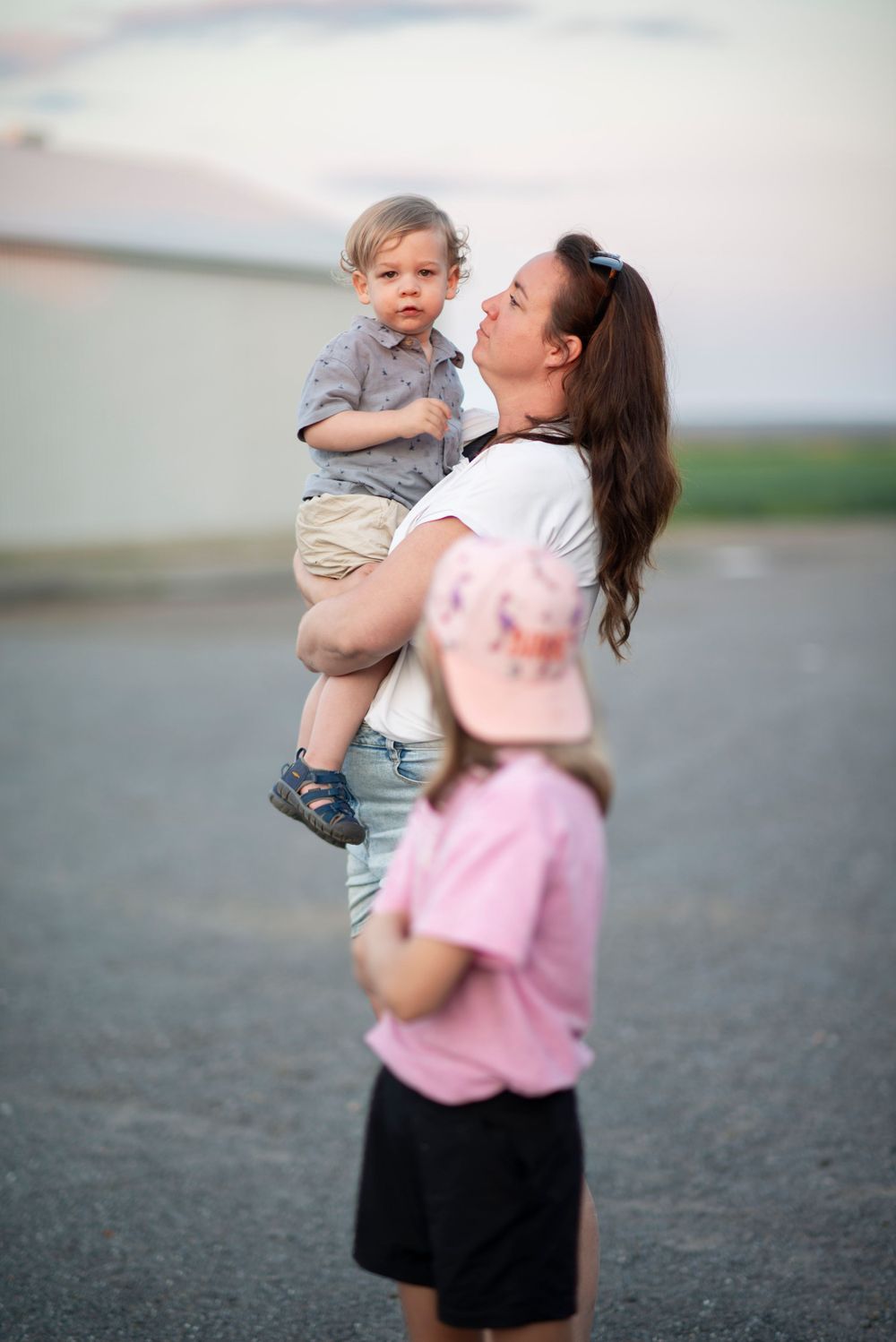 A tender family moment captured outdoors at dusk with soft lighting and natural backdrop.