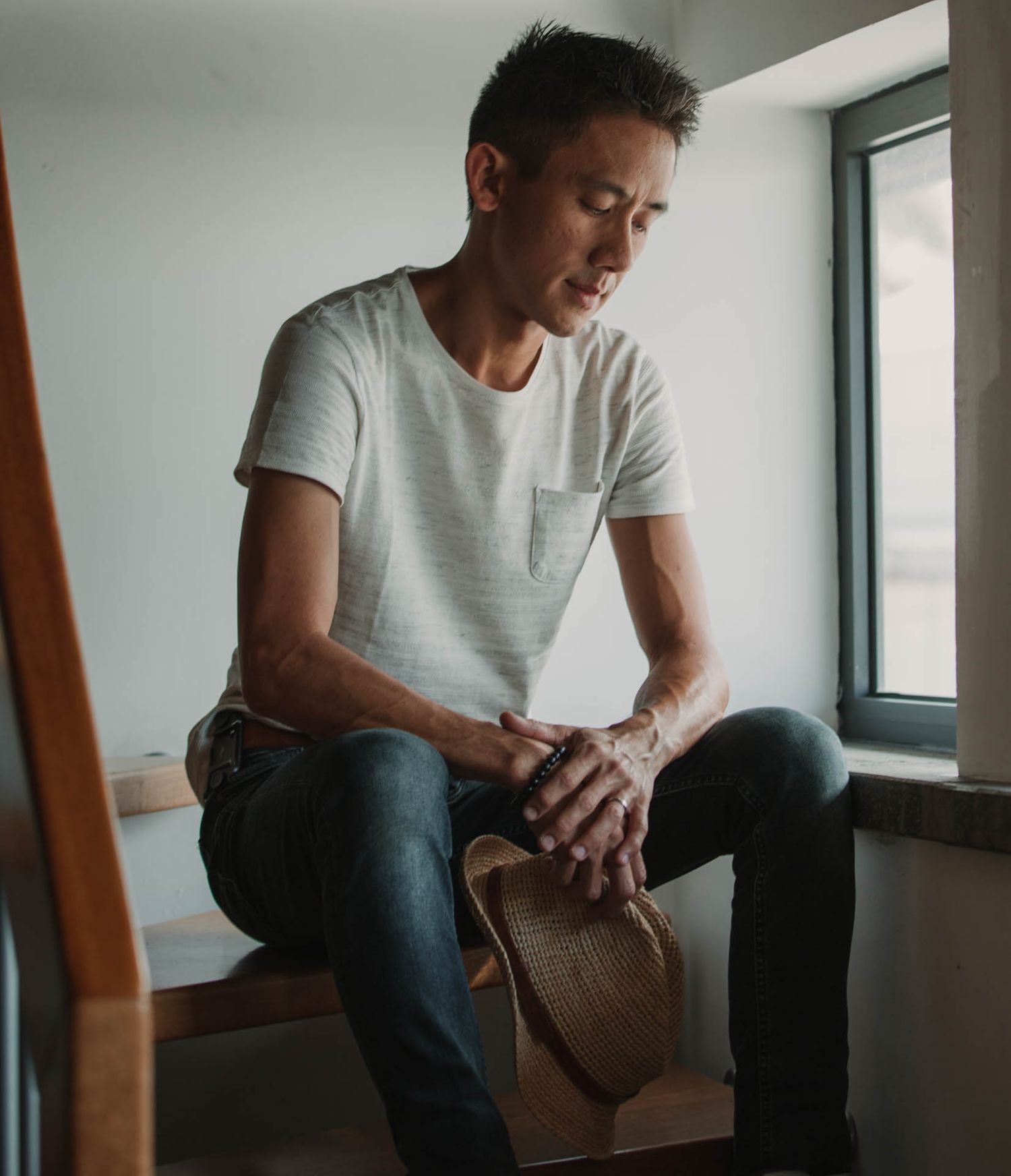 Moody interior shots showing a person sitting thoughtfully by a window in natural light.