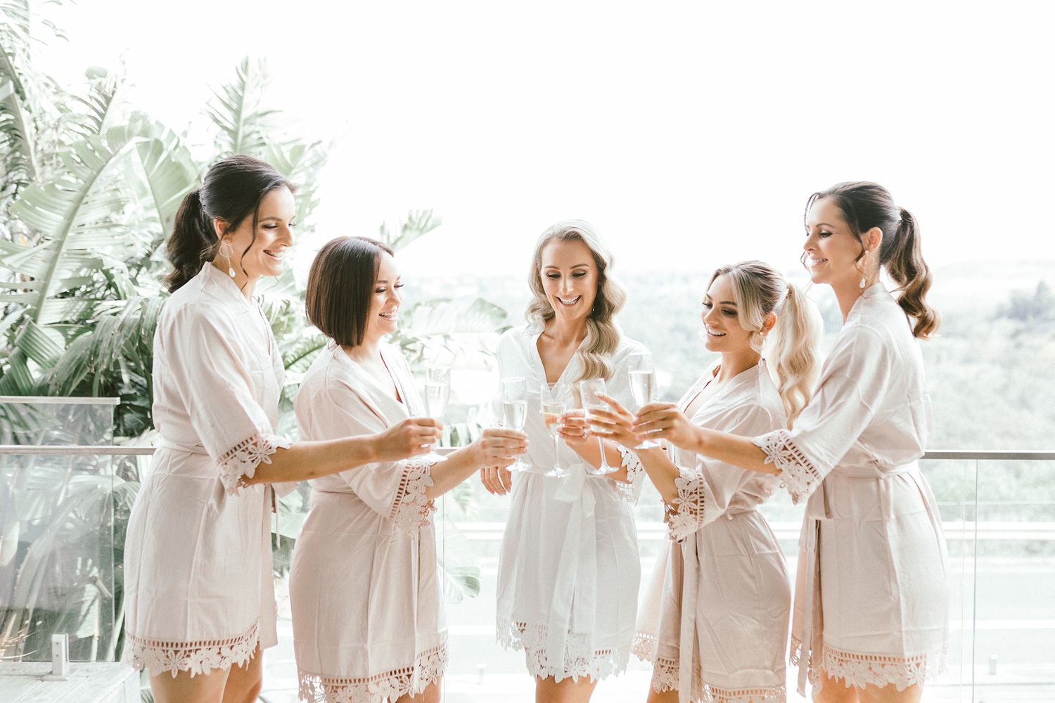 Group toasting with champagne glasses while wearing matching robes.