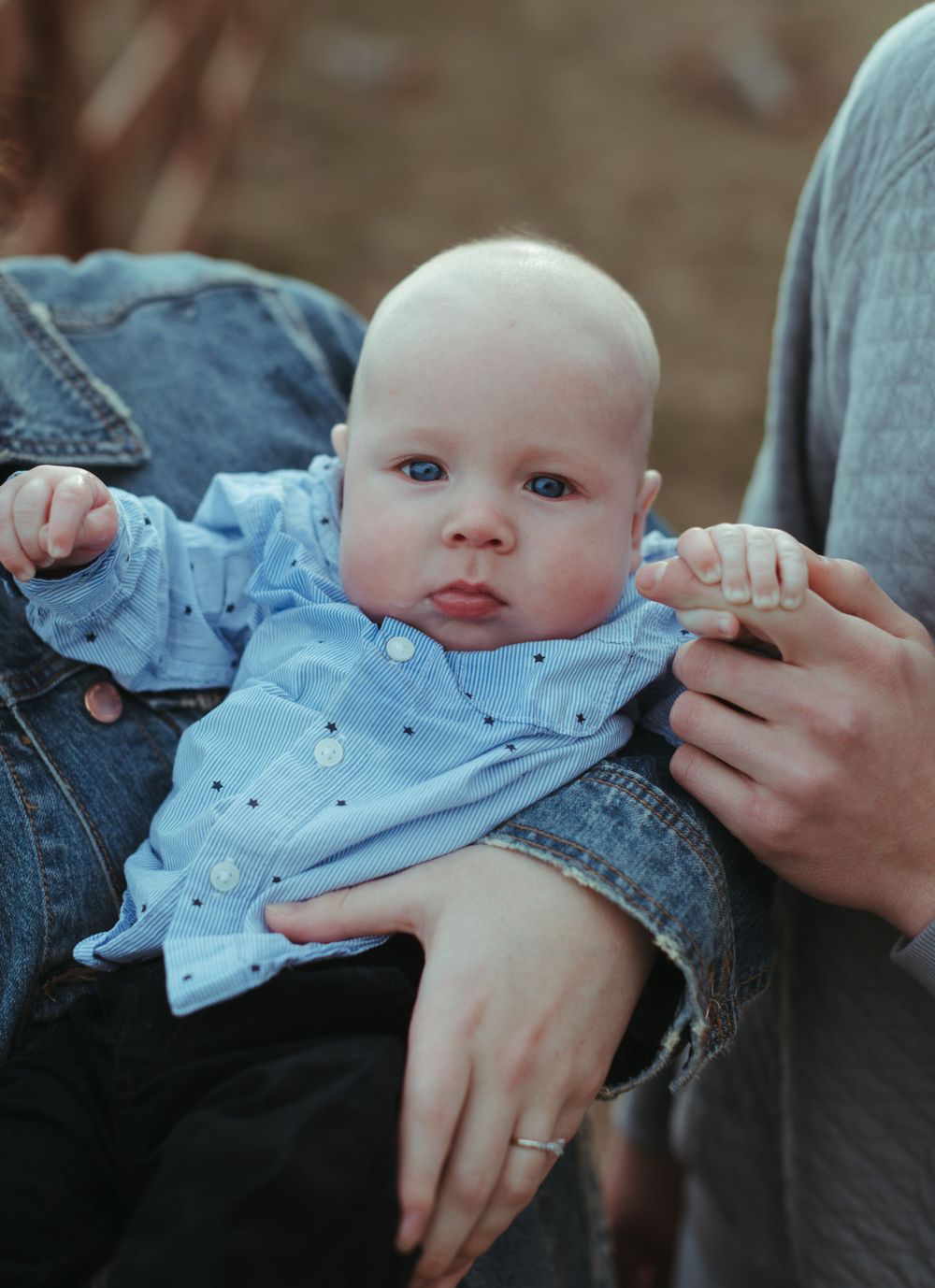 Close-up shots of baby wearing denim and blue clothing while being held.