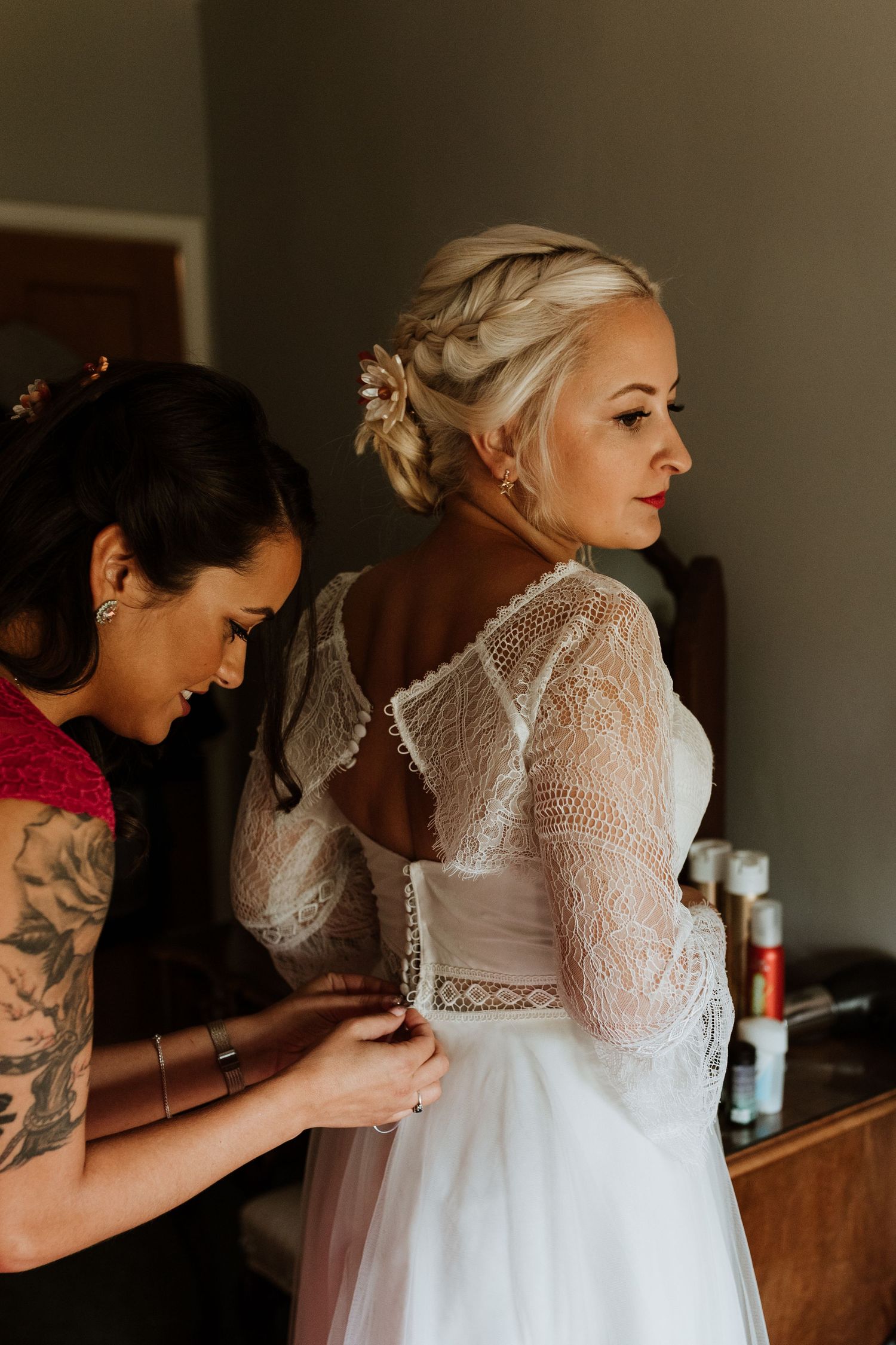 dolly blues bridal dress being done up from the back by bridesmaid
